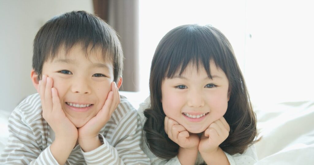 笑顔でほおづえをつく兄弟