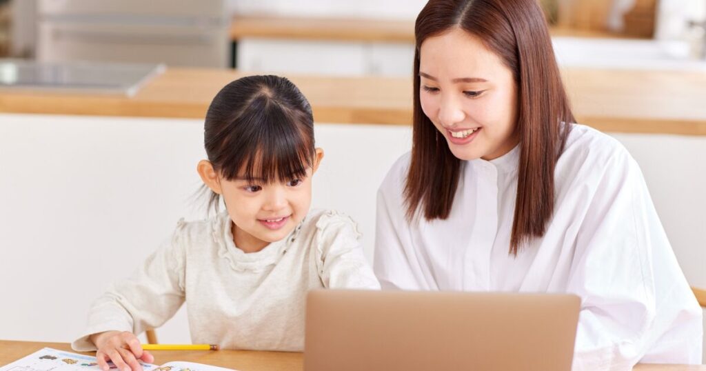 パソコンで調べものをする母娘
