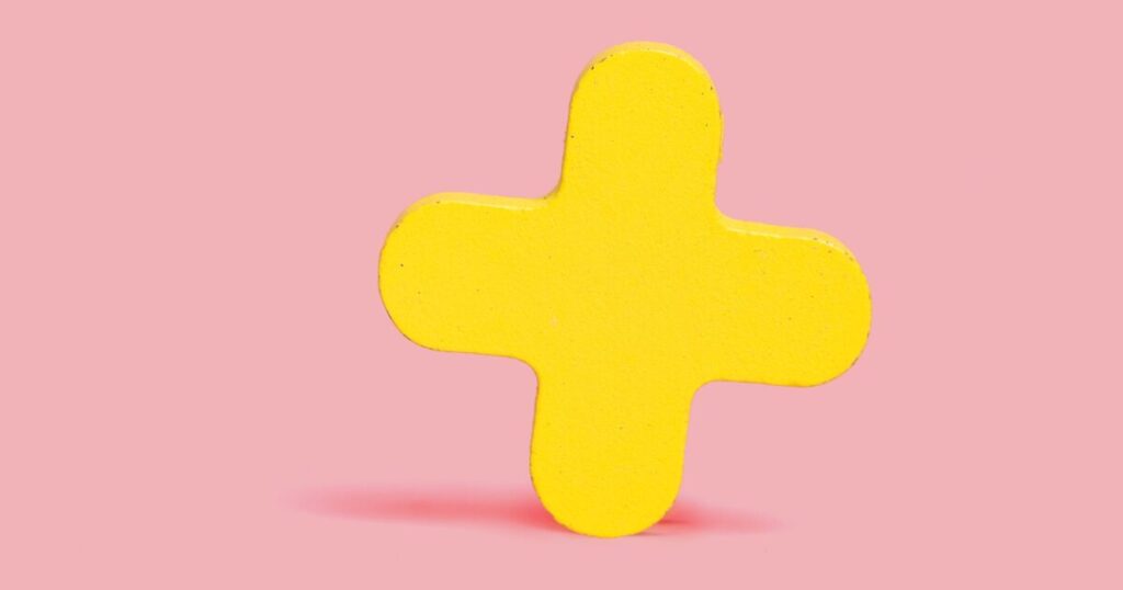 ピンクの背景に映える黄色のプラス