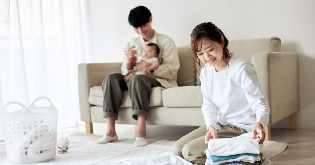 明るいリビングで家事育児をする夫婦