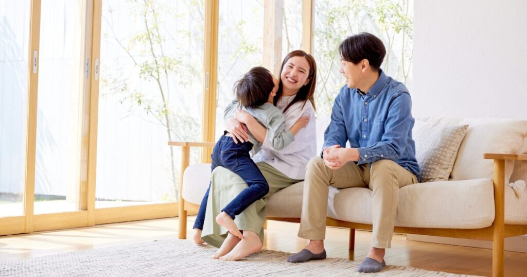 明るいリビングで団らんする3人家族
